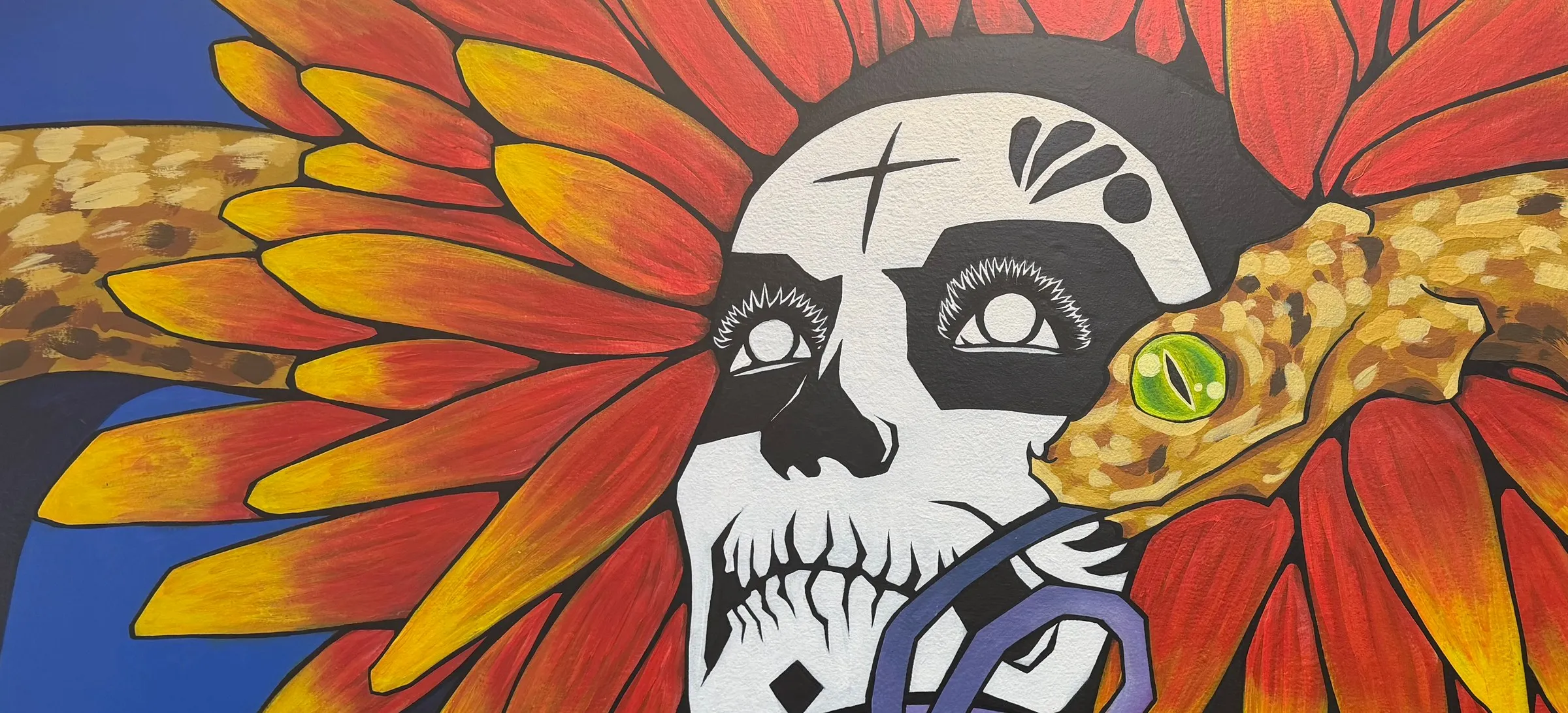 Mural de la catrina con tocado de girasol y serpiente en el estudio de Bacaanda